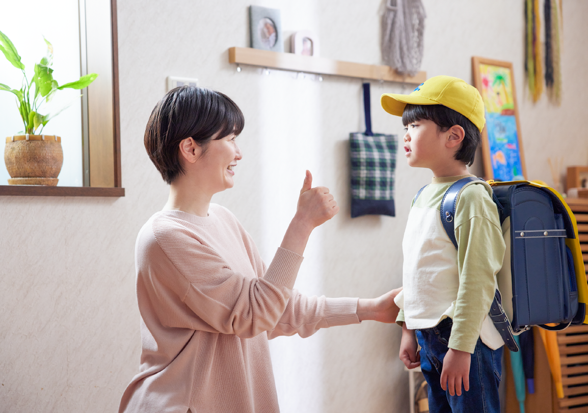 登校前に母親が子どもに話しかけている様子の写真