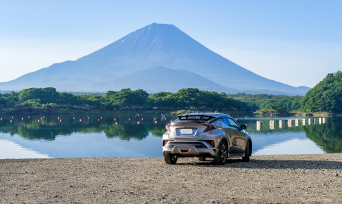 湖のほとりに停まる車の風景写真