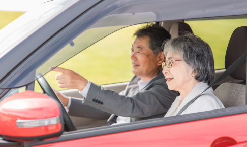 車を運転する夫婦の写真