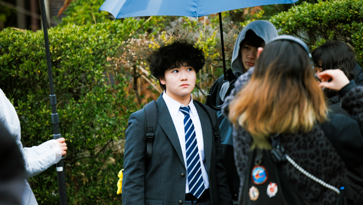 メイキング風景:雨の中で立つ制服姿の高村さん